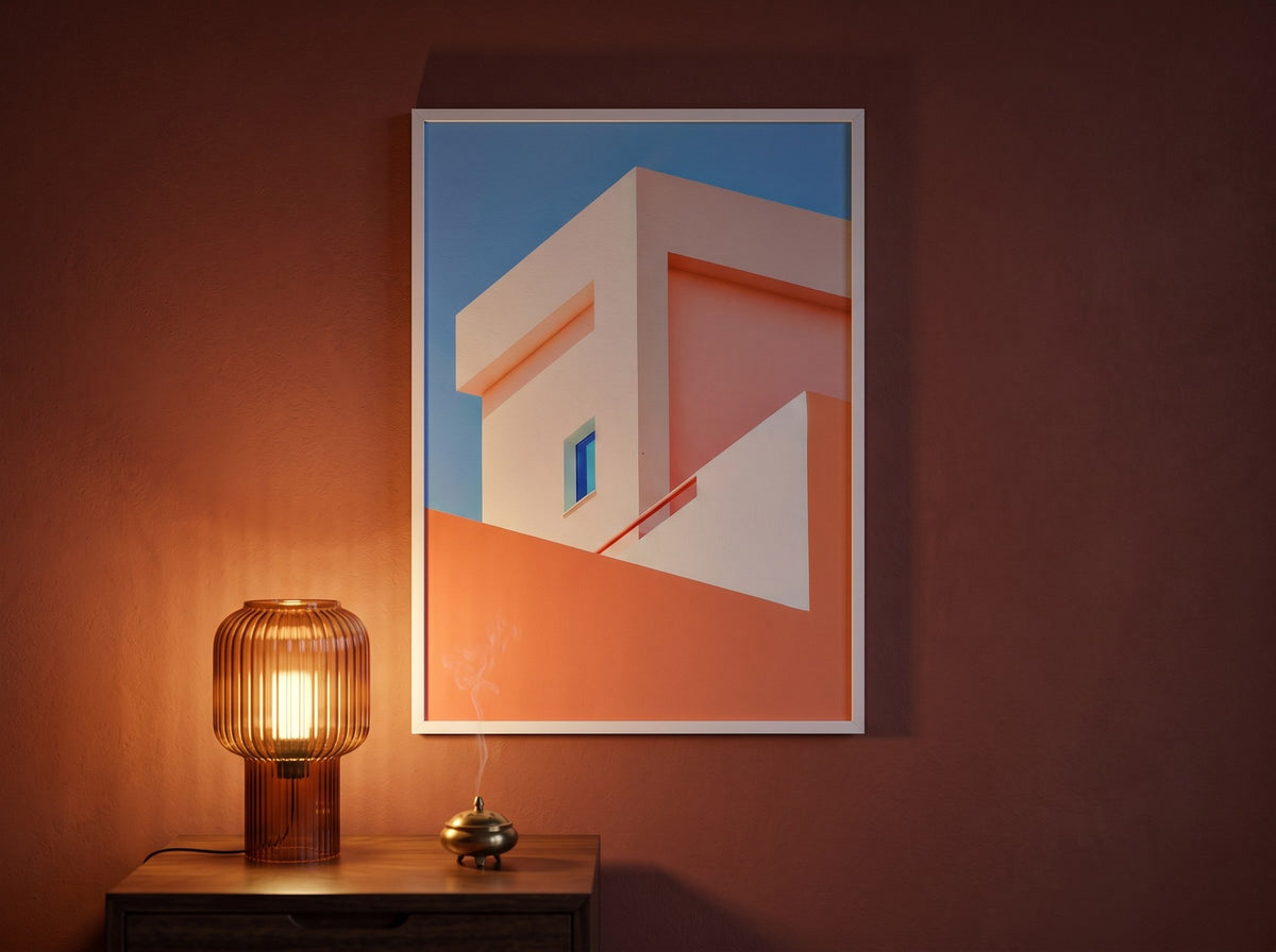Geometrik mimari poster, akşam ışığında bordo duvarda amber masa lambasının üzerinde beyaz çerçeveli