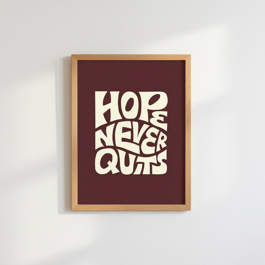 Hope Never Quits yazılı bordo retro tipografi posteri, beyaz duvarda doğal ahşap çerçeveli