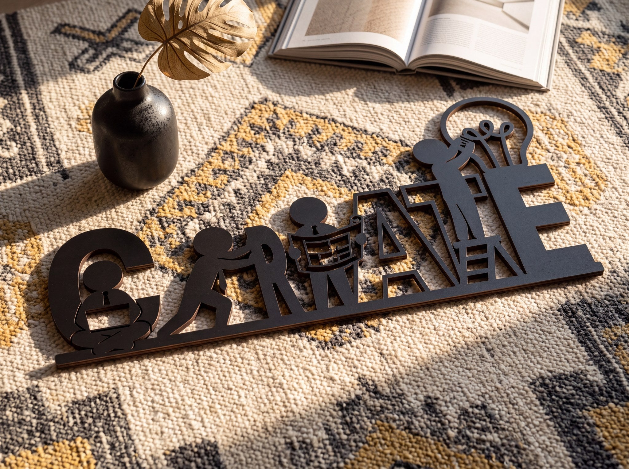 Create yazılı ofis duvar dekoru, hardal desenli kilim üzerinde vazo ve kitap yanında üstten çekim