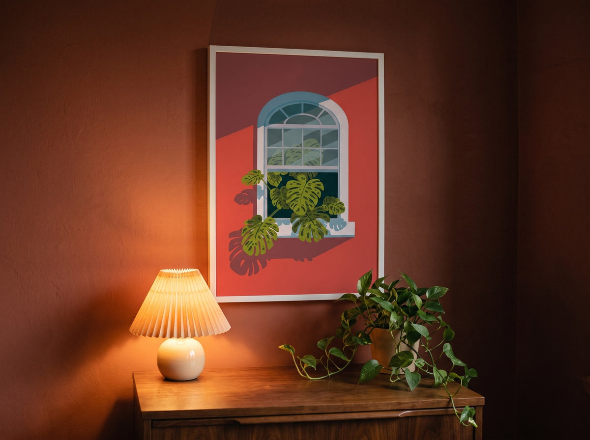 Botanik monstera posteri, akşam pliseli abajurun ışığında kiremit rengi duvarda beyaz çerçeveli