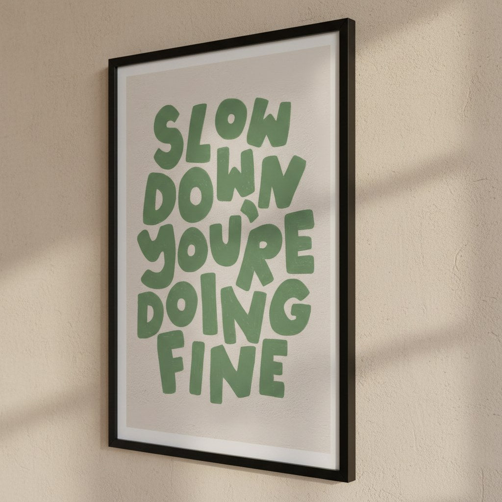 Slow Down You're Doing Fine posteri, bej duvarda siyah çerçeveli yandan görünüm